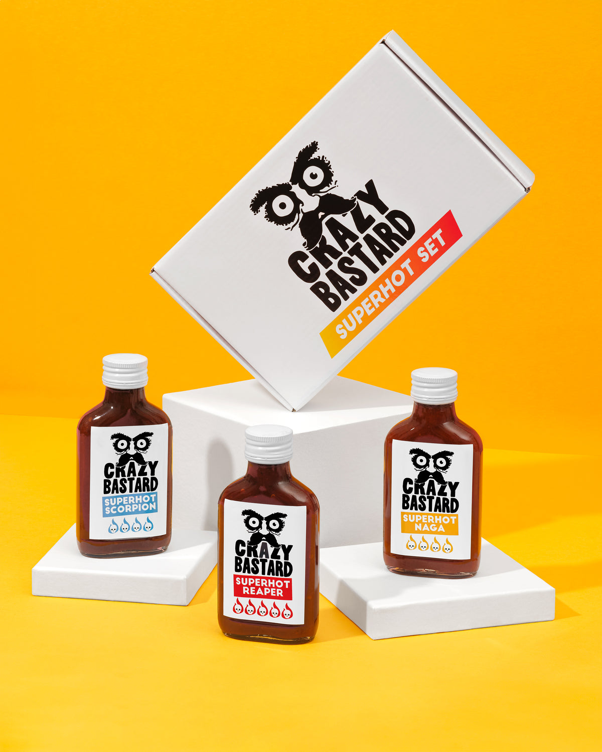 Emballage du Crazy Bastard Superhot Set avec trois bouteilles de sauce sur fond jaune