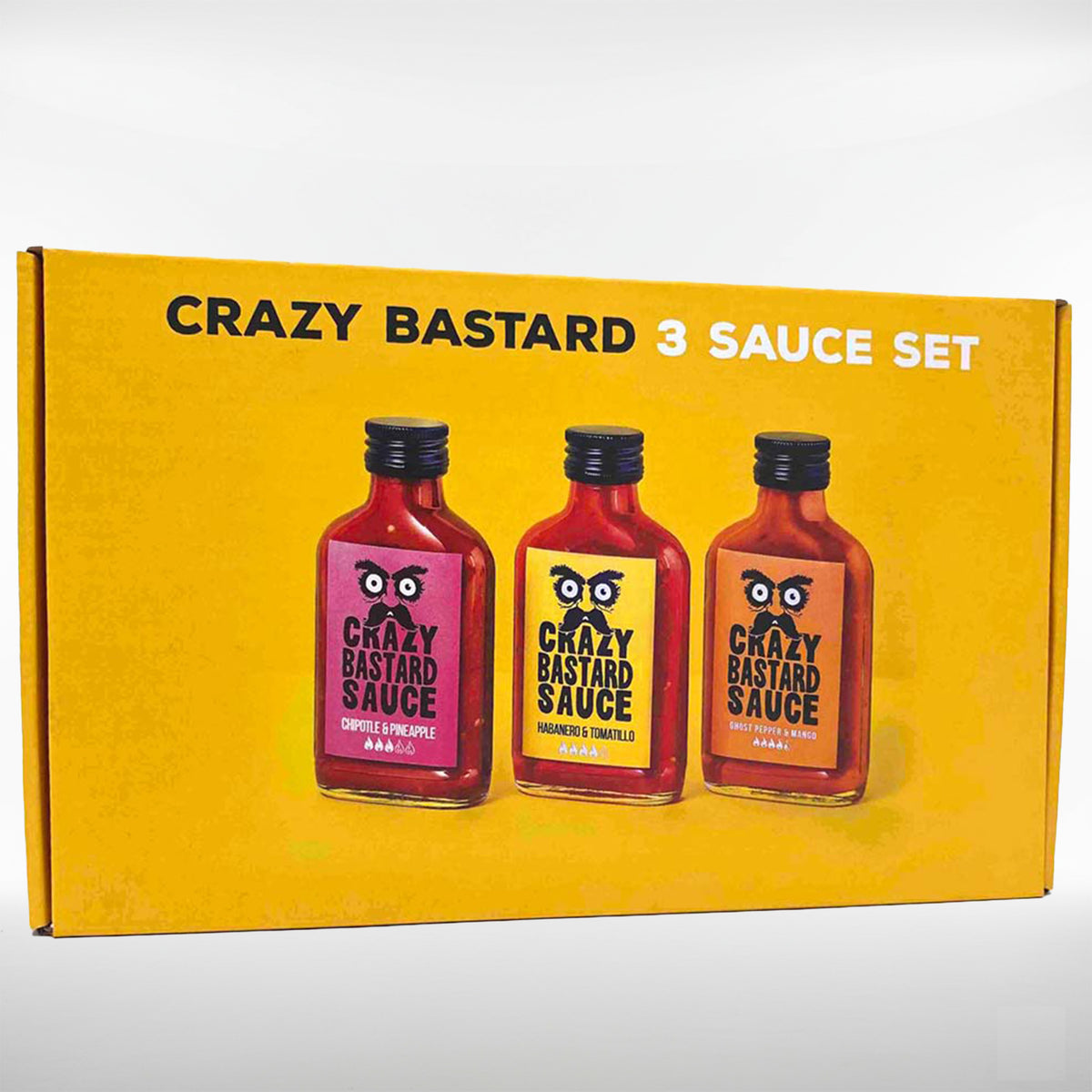 Coffret cadeau de trois sauces Crazy Bastard en emballage jaune avec trois bouteilles de sauce