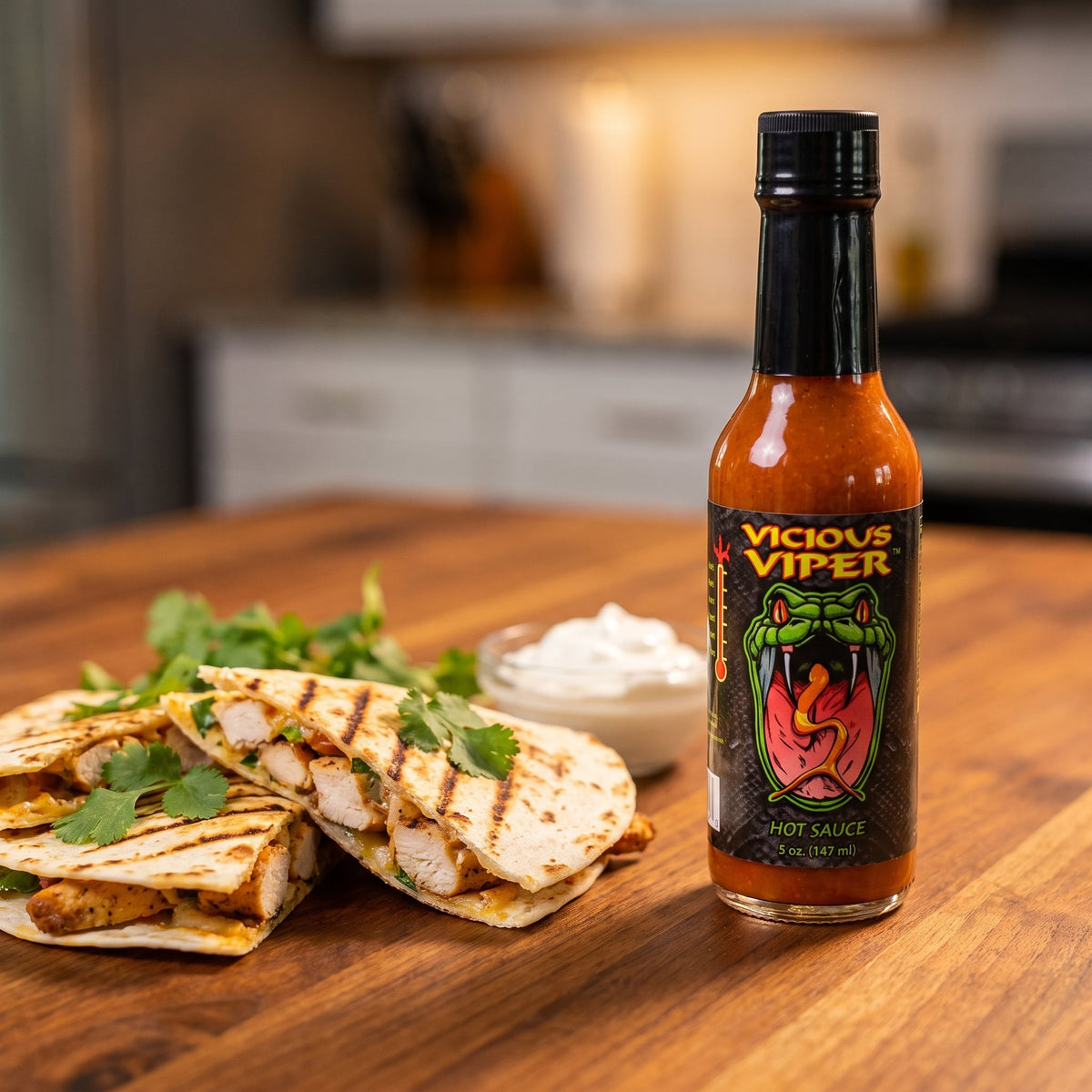 CaJohn's Vicious Viper Hot Sauce neben Hähnchen-Quesadillas mit Sauerrahm