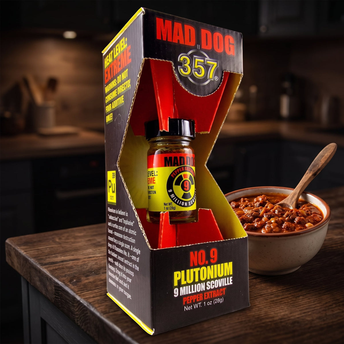 Estratto di peperoncino Mad Dog 357 No. 9 Plutonium nella sua confezione accanto a una ciotola di chili con carne