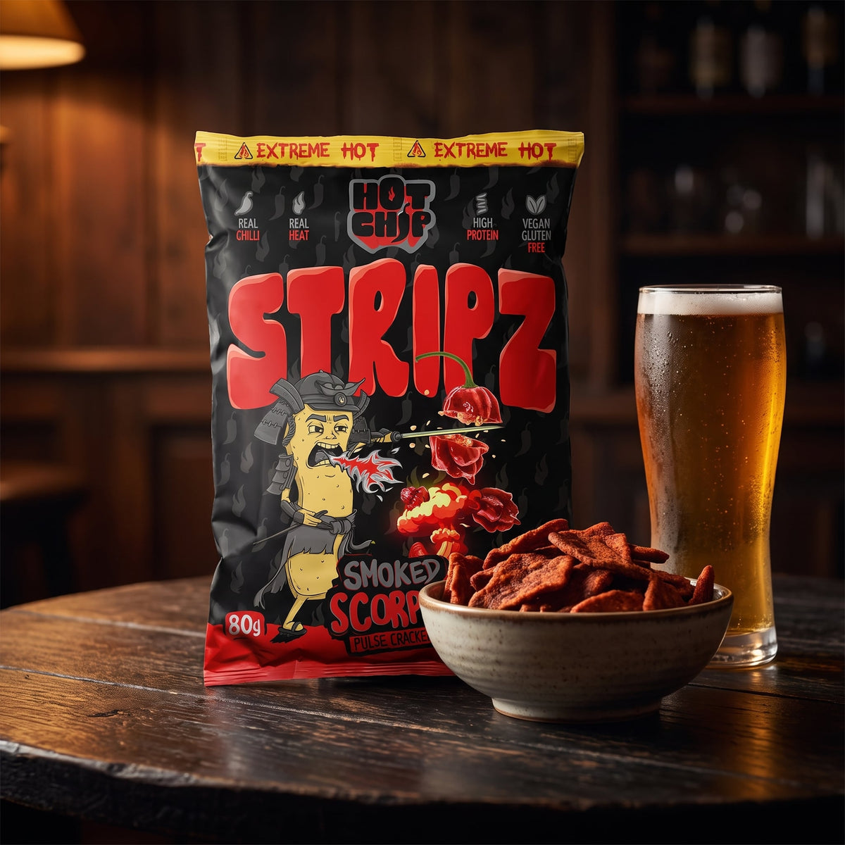 Hot Chip Stripz Smoked Scorpio Packung neben einer Schale Cracker und einem Glas Bier