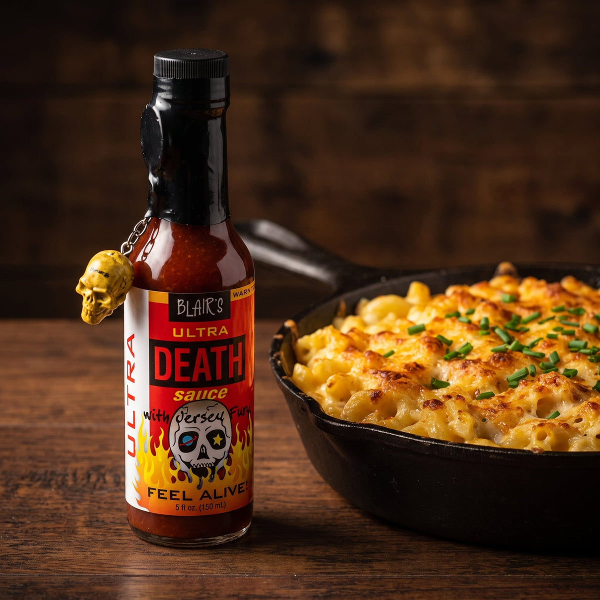 Blair's Ultra Death Hot Sauce neben einer Pfanne Mac and Cheese mit Schnittlauch