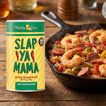 Slap Ya Mama Cajun Seasoning Low Sodium Streuer neben einer Pfanne Jambalaya mit Garnelen