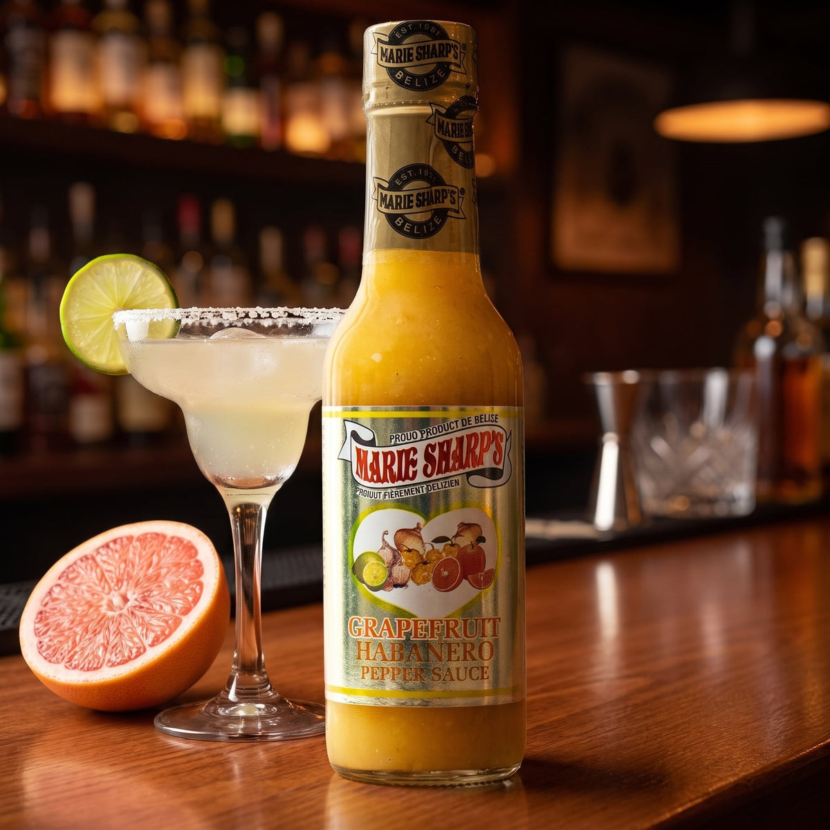 Marie Sharp's Grapefruit Pulp Habanero Sauce neben einer Margarita mit Salzrand und halber Grapefruit