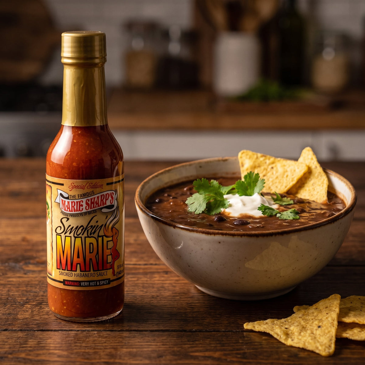Marie Sharp's Smokin' Marie Habanero Sauce neben einer Schale schwarzer Bohnensuppe mit Tortillachips