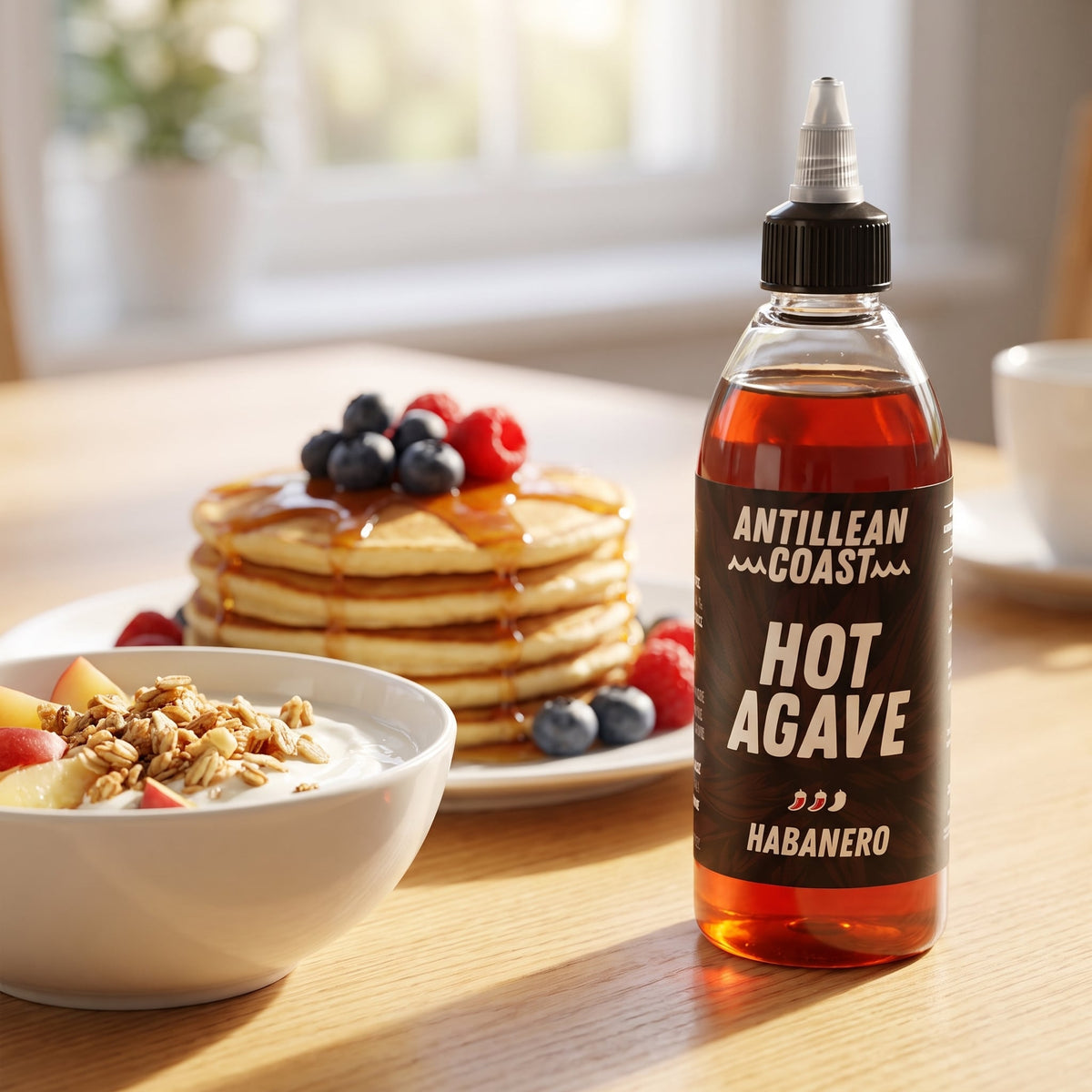 Hot Agave Habanero Sauce auf dem Frühstückstisch neben Pancakes mit Beeren und Joghurt