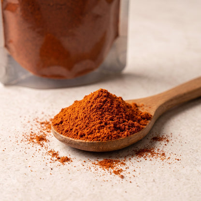 Naga Bhut Jolokia Chilipulver auf Holzlöffel, Beutel im Hintergrund