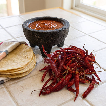 Getrocknete De Arbol Chilischoten neben einem Molcajete mit Salsa und Maistortillas