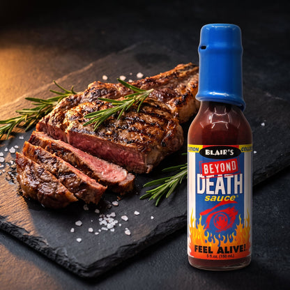 Blair's Beyond Death Hot Sauce neben gegrilltem Ribeye-Steak auf dunklem Schieferbrett