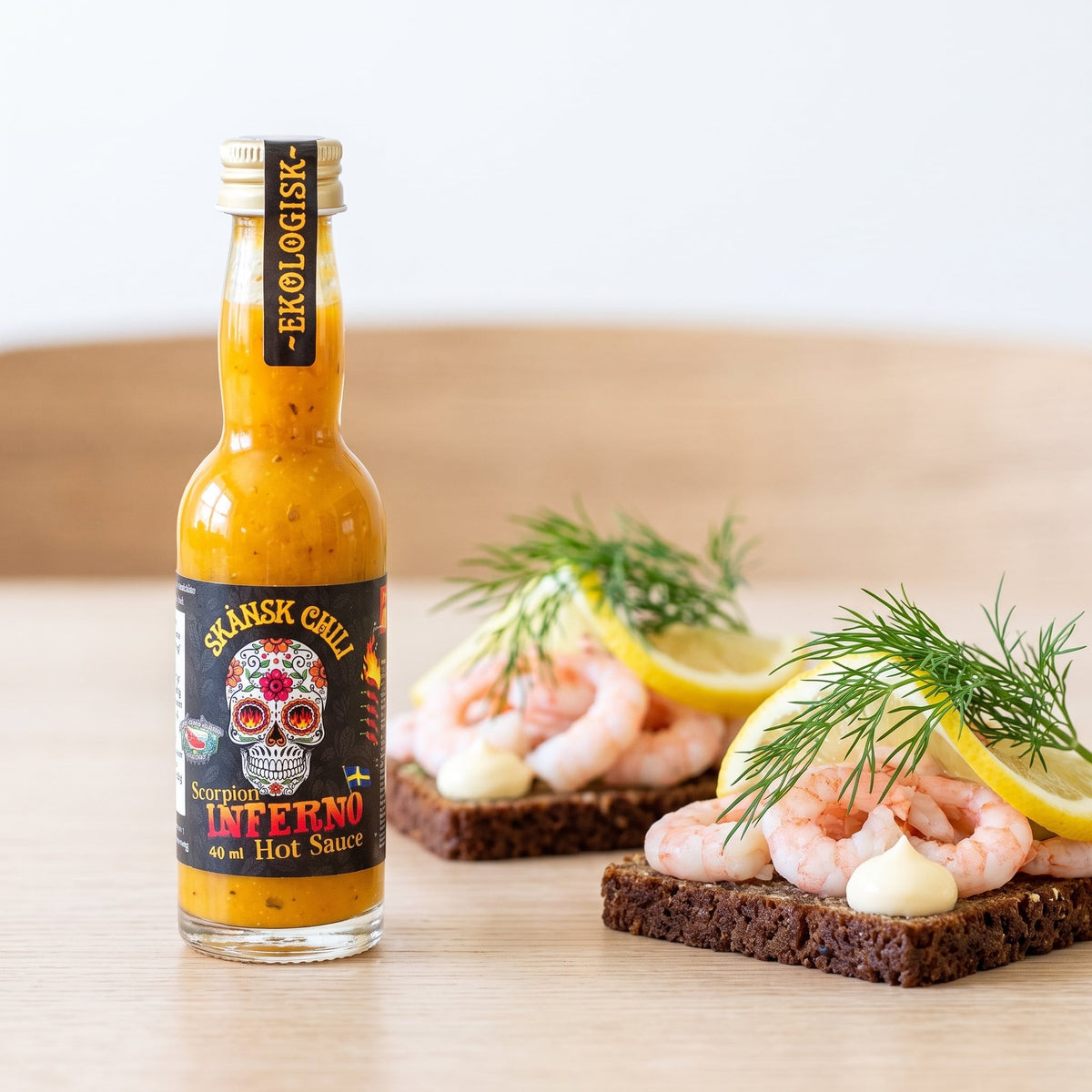Skånsk Chili Scorpion Inferno Hot Sauce neben skandinavischen Broten mit Crevetten und Dill