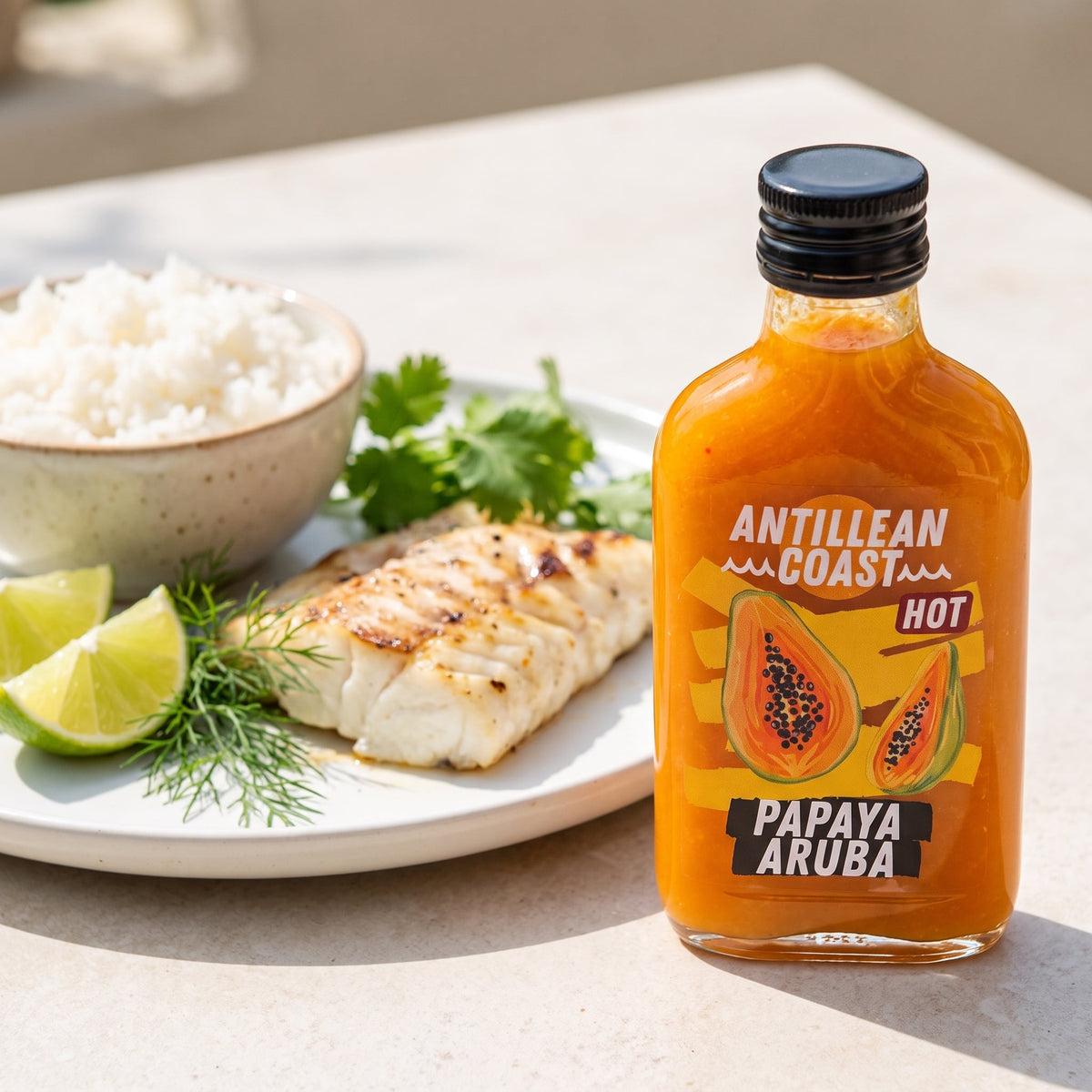 Papaya Aruba Hot Sauce à côté d'un filet de poisson grillé avec citron vert et riz