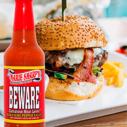 Marie Sharp's Beware Habanero Sauce vor einem Burger mit Speck und Käse
