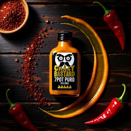 7Pot Puro Chili Sauce Flasche auf dunklem Holz neben Chiliflocken und roten Chilischoten