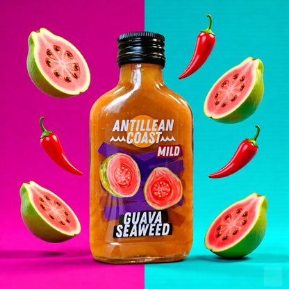 Guava Seaweed Hot Sauce Flasche zwischen Guaven und Chilis vor pink-türkisem Hintergrund
