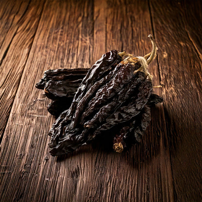 Getrocknete Mulato Chilischoten auf dunklem Holz