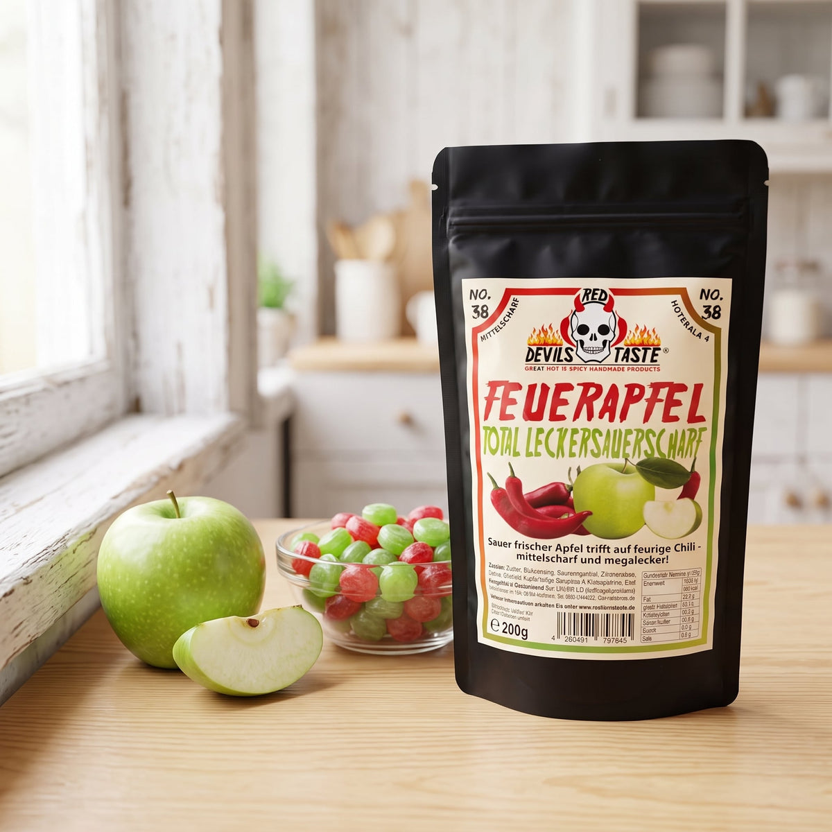 Feuerapfel Chili Bonbons Beutel neben einer Schale Bonbons und einem grünen Apfel