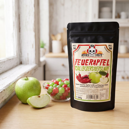 Feuerapfel Chili Bonbons Beutel neben einer Schale Bonbons und einem grünen Apfel