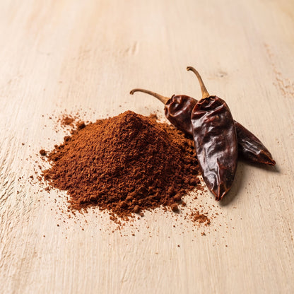 Chipotle Chilipulver mit geräucherten Chipotle-Schoten auf Holzuntergrund