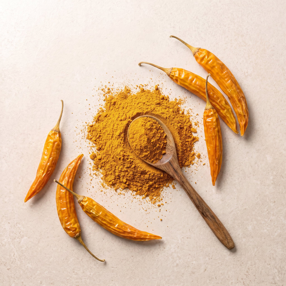 Aji Amarillo Chilipulver in der Vogelperspektive mit Holzlöffel und Chilischoten