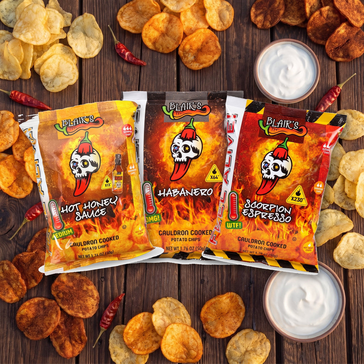 Blair's Chips 3er Set auf einem Holztisch mit Kessel Chips, getrockneten Chilis und Sauerrahm-Dip