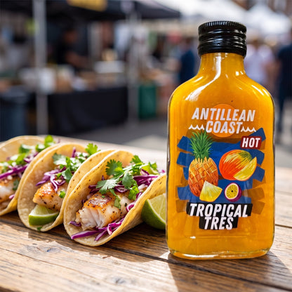 Tropical Tres Hot Sauce neben drei Fisch-Tacos mit Rotkohl und Limette