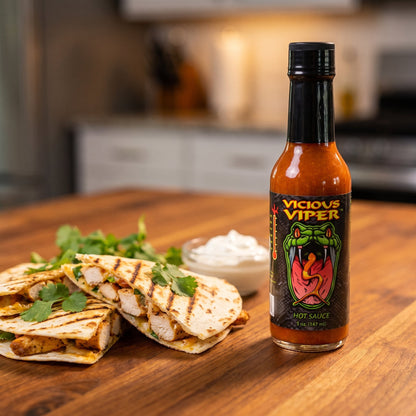 CaJohn's Vicious Viper Hot Sauce neben Hähnchen-Quesadillas mit Sauerrahm