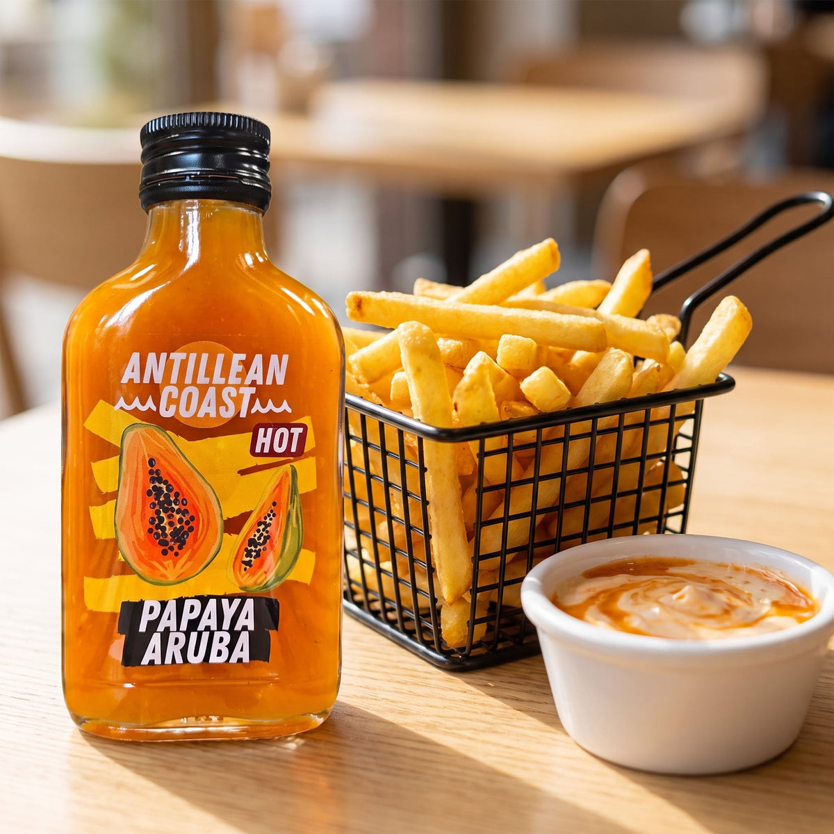 Papaya Aruba Hot Sauce à côté d'un panier de frites et d'une sauce dip