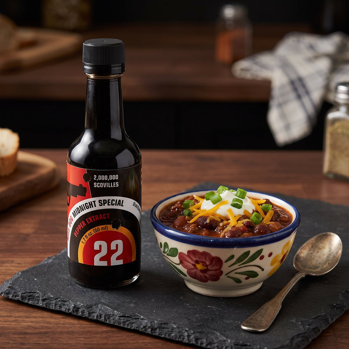 Mad Dog 22 Midnight Special Chili-Extrakt neben einer Schale Chili mit Käse und Frühlingszwiebeln