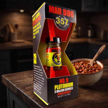 Estratto di peperoncino Mad Dog 357 No. 9 Plutonium nella sua confezione accanto a una ciotola di chili con carne